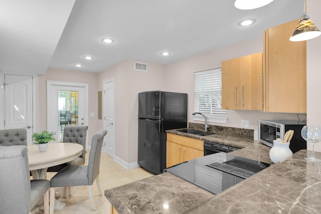 kitchen featuring light brown cabinets, black appliances, a sink, healthy amount of natural light, and recessed lighting
