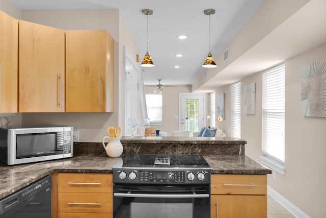 kitchen featuring black appliances, a peninsula, baseboards, dark stone counters, and decorative light fixtures
