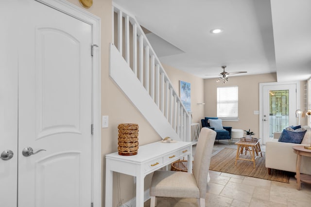 interior space with stone tile flooring, stairway, and a ceiling fan
