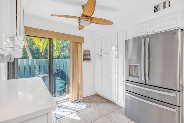 kitchen with stainless steel refrigerator with ice dispenser, white cabinetry, ceiling fan, and light tile patterned floors