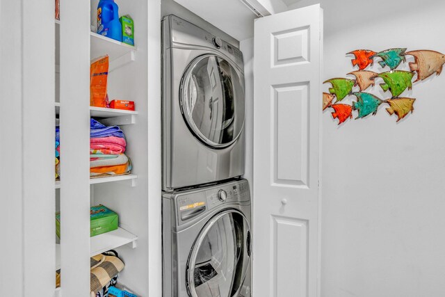 clothes washing area with stacked washer and clothes dryer