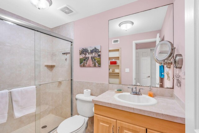 bathroom with walk in shower, vanity, and toilet