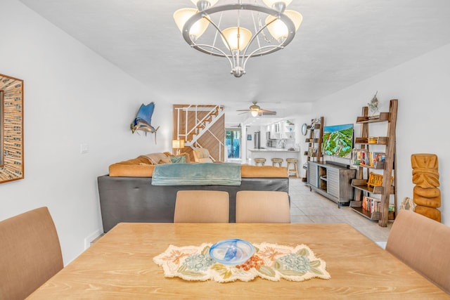 tiled dining space with ceiling fan with notable chandelier