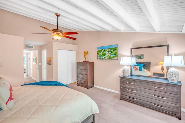 carpeted bedroom featuring lofted ceiling with beams, a closet, and ceiling fan