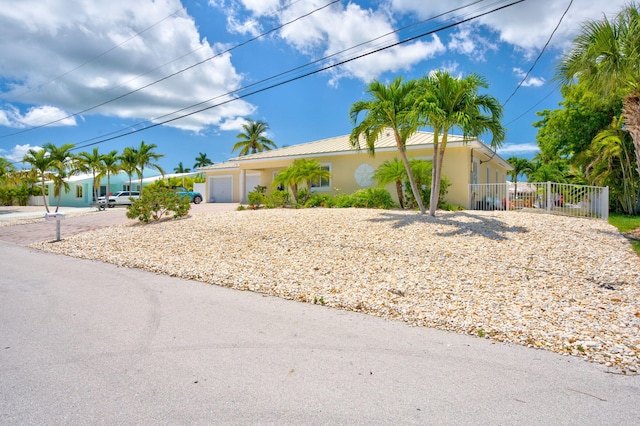 20771 W 2nd Ave, Cudjoe, FL 33042 - view of front of property with concrete driveway, stucco siding, a garage, and a metal roof