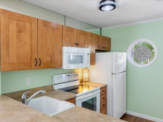 kitchen featuring crown molding, white appliances, and sink