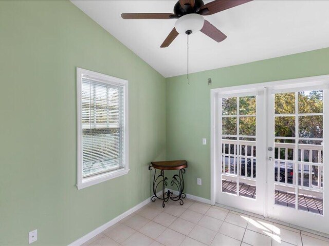 doorway with light tile patterned floors, vaulted ceiling, and ceiling fan