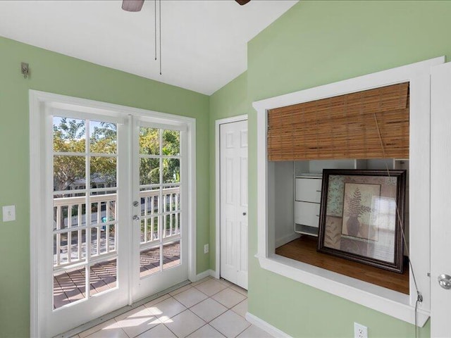 doorway to outside featuring light tile patterned flooring, ceiling fan, and vaulted ceiling