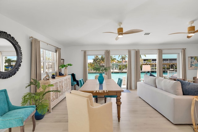 dining room with light wood-style floors, plenty of natural light, visible vents, and a ceiling fan