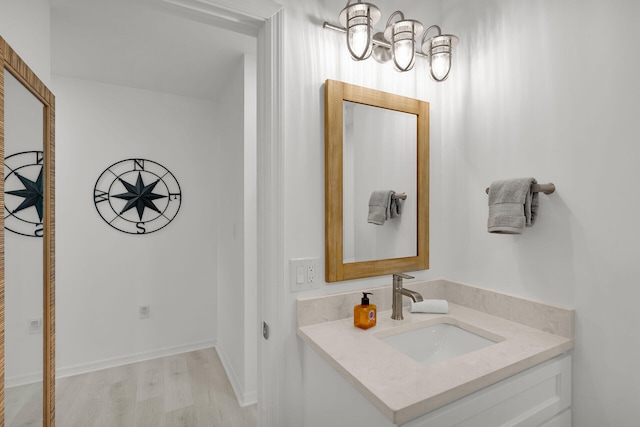 bathroom featuring an inviting chandelier, vanity, and wood finished floors