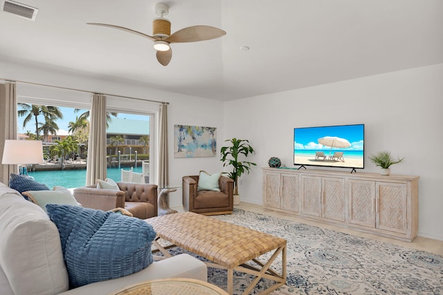 living area with visible vents, a ceiling fan, and baseboards