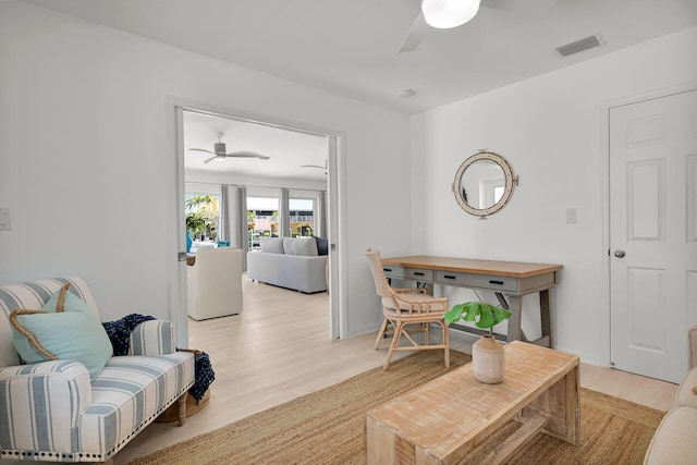 living area featuring a ceiling fan, visible vents, and light wood-style flooring
