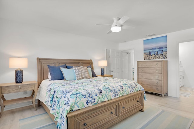 bedroom featuring ensuite bathroom, visible vents, light wood-style floors, and ceiling fan