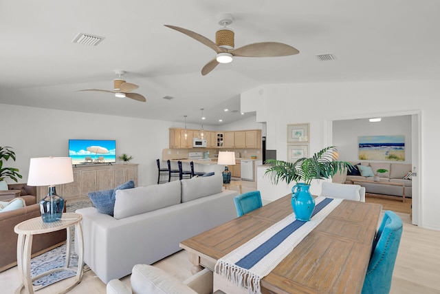 living area with light wood finished floors, lofted ceiling, visible vents, and a ceiling fan