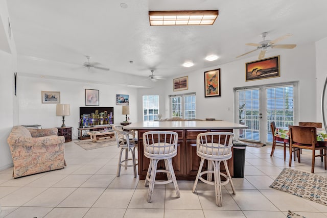 kitchen with a breakfast bar area, a center island, plenty of natural light, and light tile patterned flooring