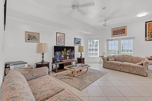 living room with ceiling fan, a textured ceiling, and light tile patterned floors