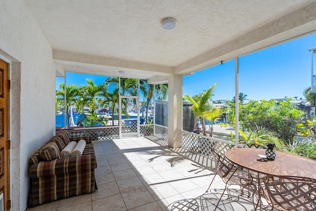 sunroom featuring a water view