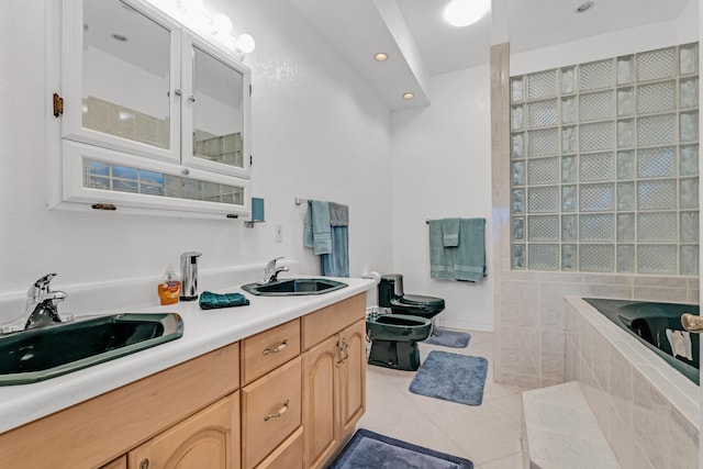 bathroom with vanity, toilet, tiled tub, a bidet, and tile patterned floors