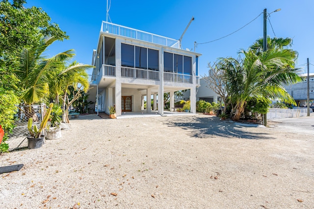 rear view of house with a carport and a sunroom