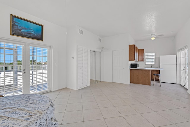 kitchen with french doors, sink, light tile patterned floors, kitchen peninsula, and white fridge