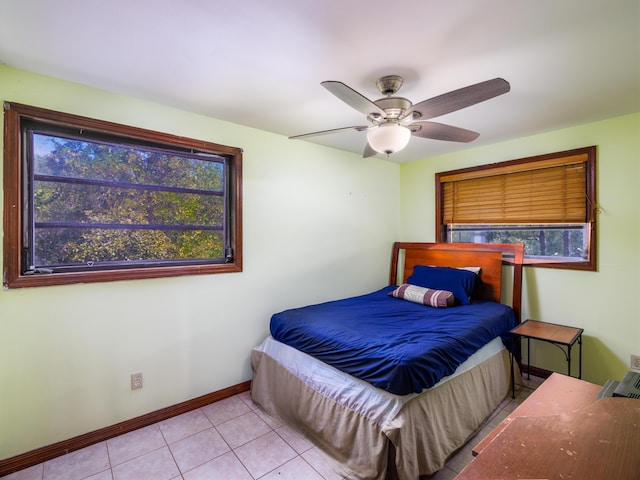 tiled bedroom with baseboards and ceiling fan