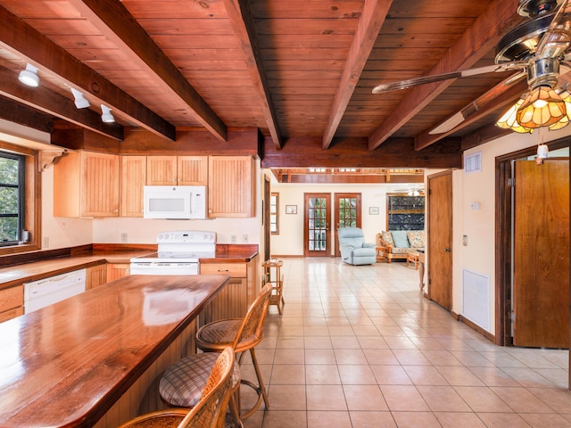 kitchen with wooden counters, visible vents, plenty of natural light, and white appliances