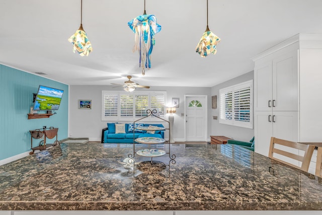 living room with a ceiling fan and baseboards