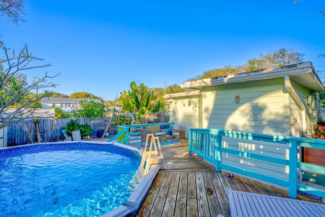 view of swimming pool with a fenced in pool, a deck, a trampoline, and a fenced backyard