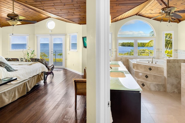 bedroom with a water view, lofted ceiling, french doors, and wooden ceiling