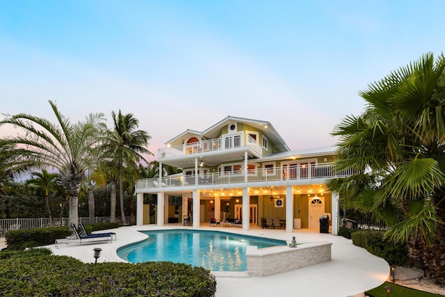 pool at dusk featuring a patio area