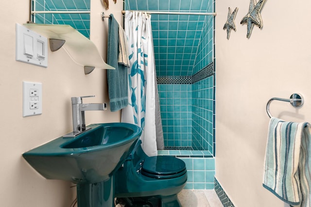 bathroom featuring sink, toilet, and a shower with shower curtain