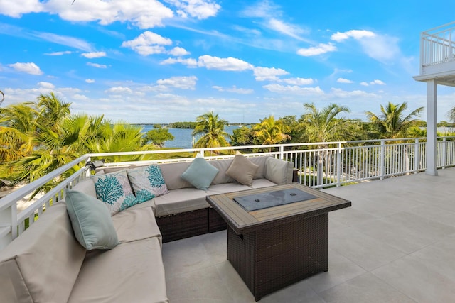 view of patio with a water view, a balcony, and an outdoor living space