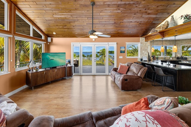 living room featuring lofted ceiling, light hardwood / wood-style floors, wooden ceiling, and french doors