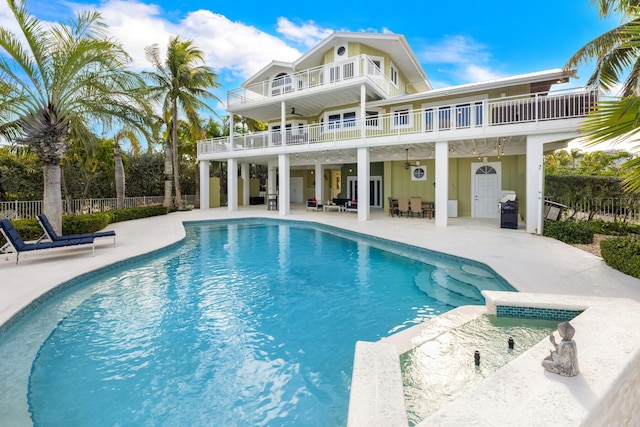 rear view of house featuring a balcony, a fenced in pool, and a patio area