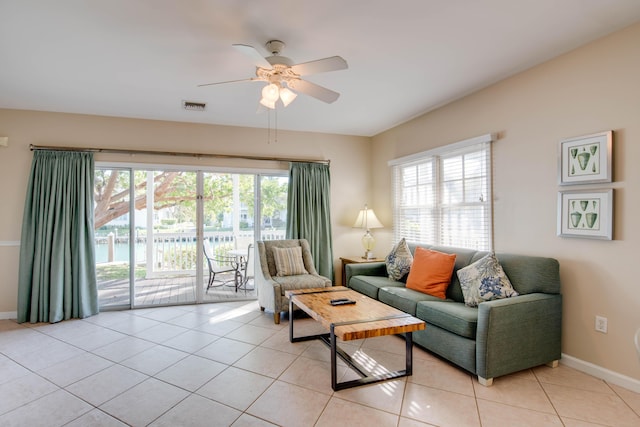 tiled living room with a wealth of natural light and ceiling fan