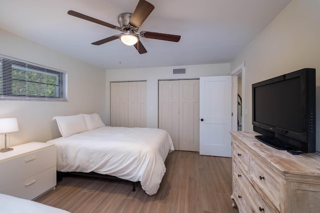 88181 Old Hwy Unit 3F, Islamorada, FL 33036 - bedroom featuring two closets, wood finished floors, and a ceiling fan