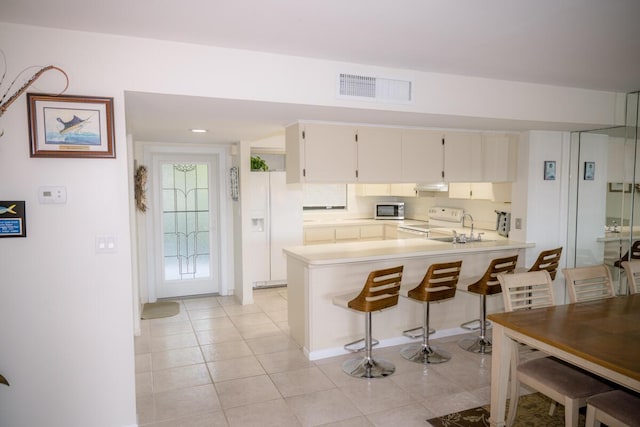 88181 Old Hwy Unit 3F, Islamorada, FL 33036 - kitchen with white appliances, light countertops, light tile patterned floors, and a peninsula