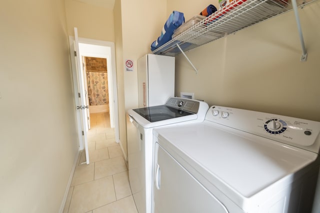 laundry room with light tile patterned floors and washing machine and clothes dryer