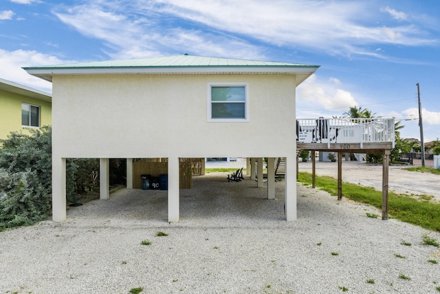 rear view of property with a wooden deck and a carport