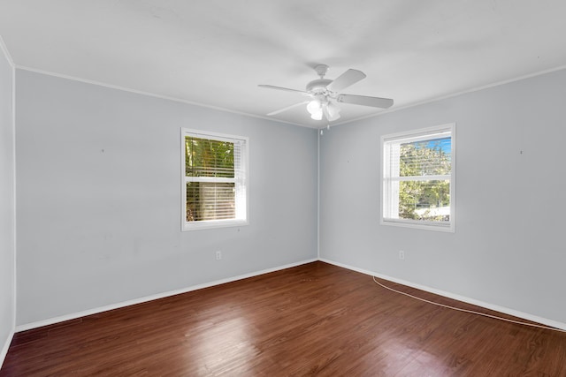 empty room with ornamental molding, dark wood-type flooring, and a wealth of natural light