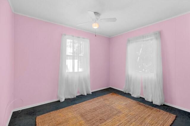 unfurnished room featuring ceiling fan and dark carpet