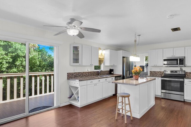 kitchen with white cabinetry, pendant lighting, a kitchen island, and appliances with stainless steel finishes