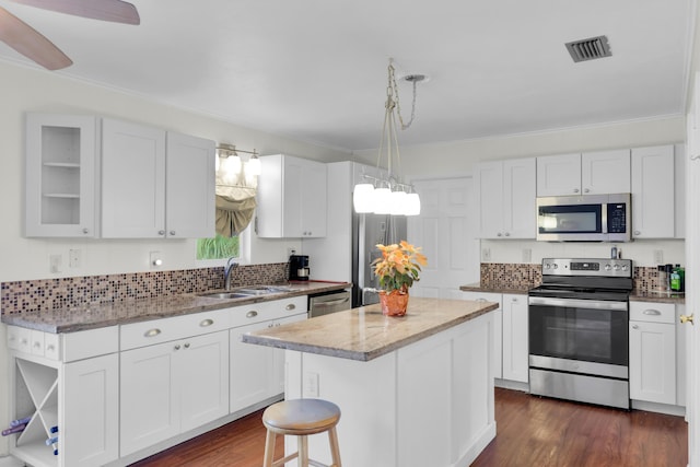 kitchen featuring sink, white cabinetry, a center island, pendant lighting, and stainless steel appliances