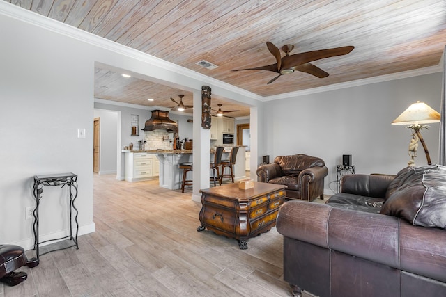 living room featuring wood ceiling, ornamental molding, and light wood-type flooring