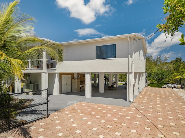 back of house featuring a balcony and central air condition unit