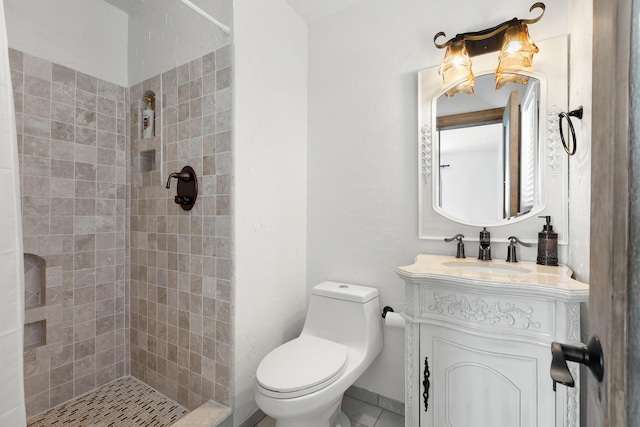 bathroom featuring tiled shower, vanity, and toilet