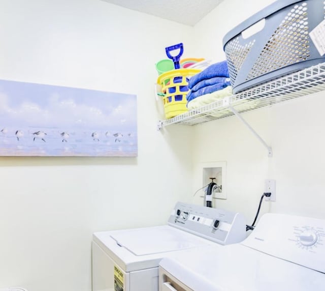 washroom with washing machine and dryer and a textured ceiling