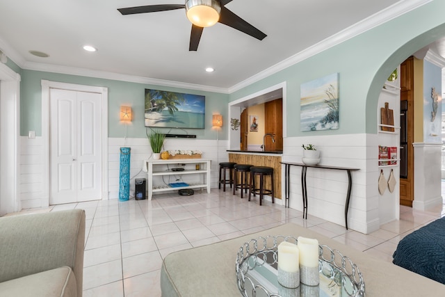 living room with crown molding, light tile patterned floors, and ceiling fan