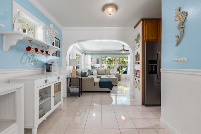 interior space with light tile patterned flooring, ceiling fan, and crown molding