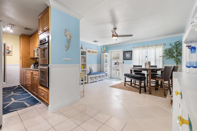 kitchen featuring crown molding, stainless steel double oven, ceiling fan, and light tile patterned floors